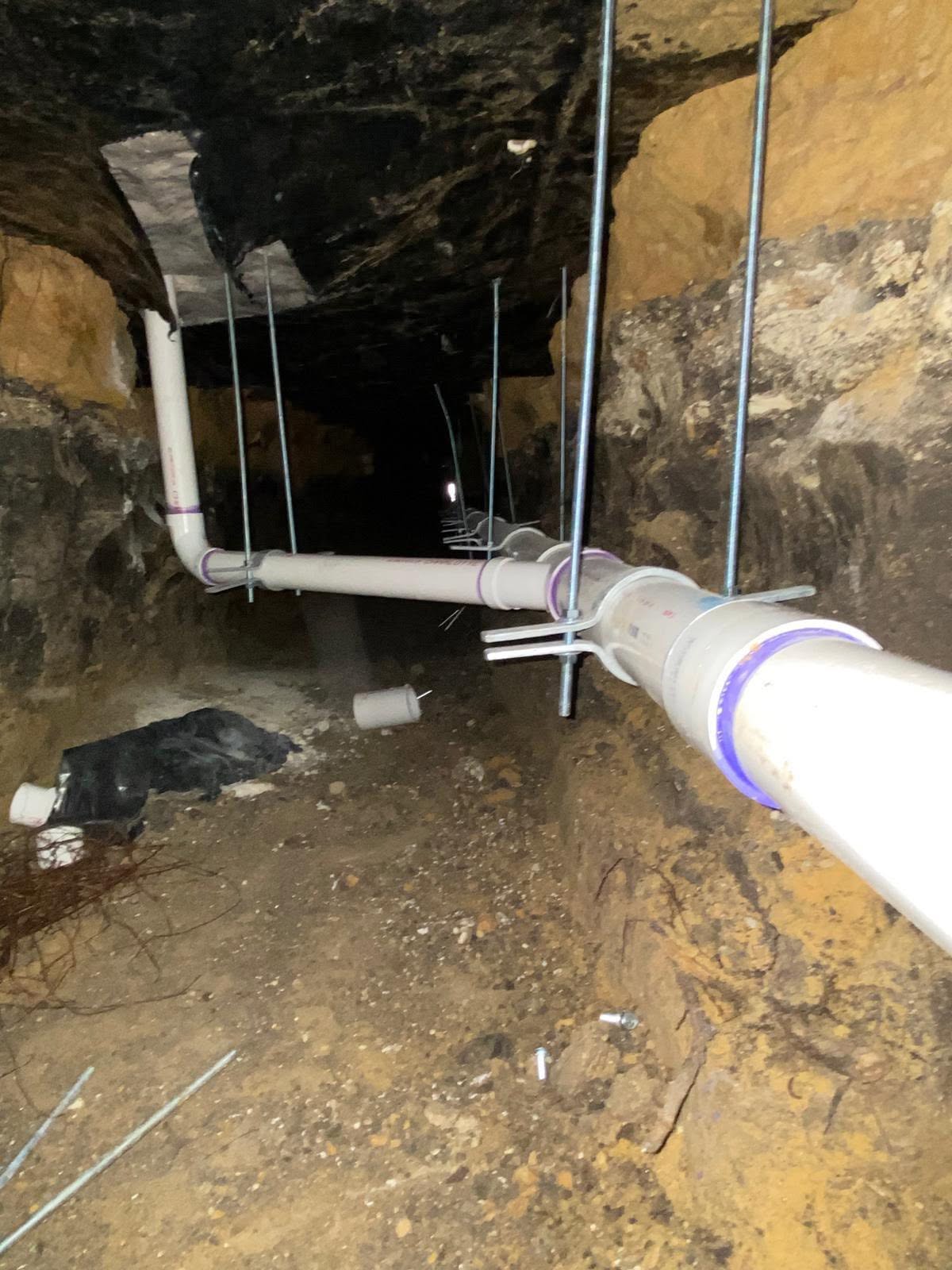 Reemplazo de línea de drenaje con tubería PVC y abrazaderas Fernco bajo la losa